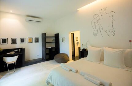 Arthur&Paul Men Only Hotel bedroom. Gay-friendly hotel room with white linens, desk, and modern art. Men-only hotel accommodation.