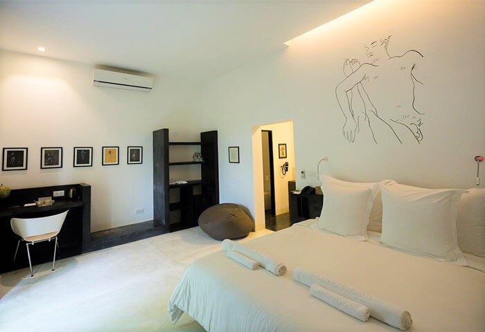 Arthur&Paul Men Only Hotel bedroom. Gay-friendly hotel room with white linens, desk, and modern art. Men-only hotel accommodation.