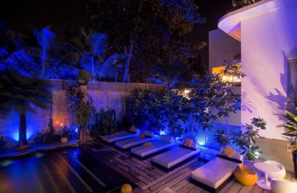 Arthur&Paul Men Only Hotel: Night view of the gay-friendly hotel's pool area. Blue lighting enhances the palm trees and lounge chairs.