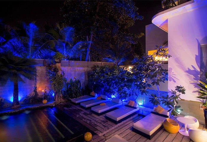 Arthur&Paul Men Only Hotel: Night view of the gay-friendly hotel's pool area. Blue lighting enhances the palm trees and lounge chairs.
