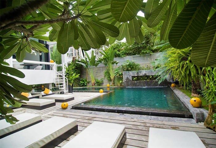 Arthur&Paul Men Only Hotel's pool area. Gay-friendly hotel with lounge chairs, tropical plants, and a modern design. A relaxing retreat for gay men.