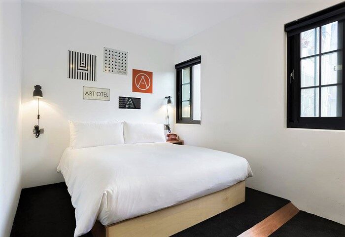 Art'otel Ximending Taipei room. Gay-friendly hotel with white bedding, black window frames, and modern art on the wall. Great for gay travelers.