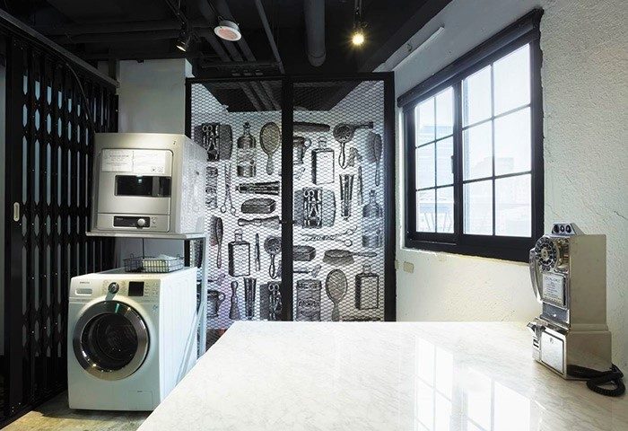 Art'otel Ximending Taipei interior. Gay-friendly hotel with laundry machines, a window, and a decorative screen with grooming tools.