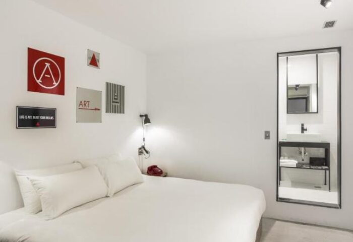 Art'otel Ximending Taipei room. Gay-friendly hotel featuring a bed, artwork, and bathroom. Modern design in Taipei's Ximending district.