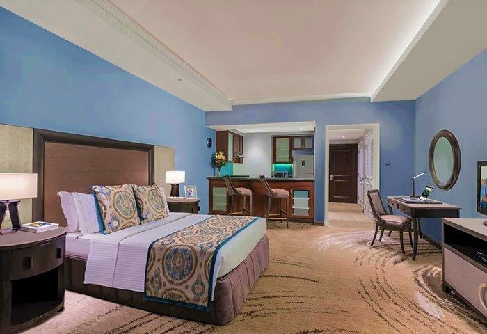 Ascott Makati gay-friendly hotel room. Bedroom with bed, desk, and kitchenette. Gay travel in Makati, Philippines. Luxury hotel suite.