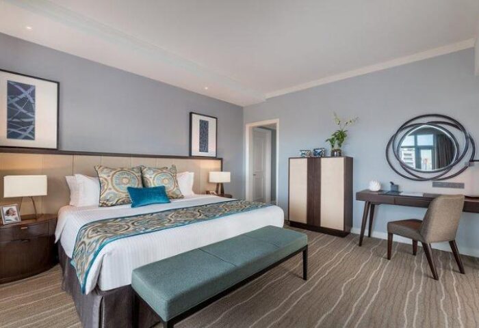 Ascott Makati gay-friendly hotel room. King bed with blue accents, desk, and modern decor. Comfortable and stylish accommodations for gay travelers.