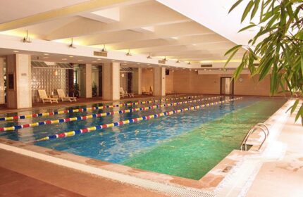 Indoor pool at Asia Hotel, a gay-friendly hotel. The pool has lane markers and lounge chairs. Asia Hotel is a great place to stay.