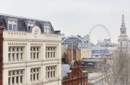 Assembly Hotel, a gay-friendly hotel. Skyline view with the London Eye, old buildings, and church tower. Travel advice for gay men in London.