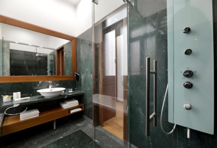 Athenaeum Eridanus Luxury Hotel bathroom. Gay-friendly hotel with marble shower, sink, mirror, and towels. Upscale design for gay travelers.