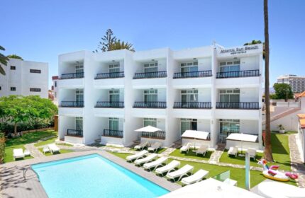 Atlantic Sun Beach, a gay-friendly hotel. White building with balconies, pool, sunbeds, and a unicorn float. Perfect for gay men's travel.