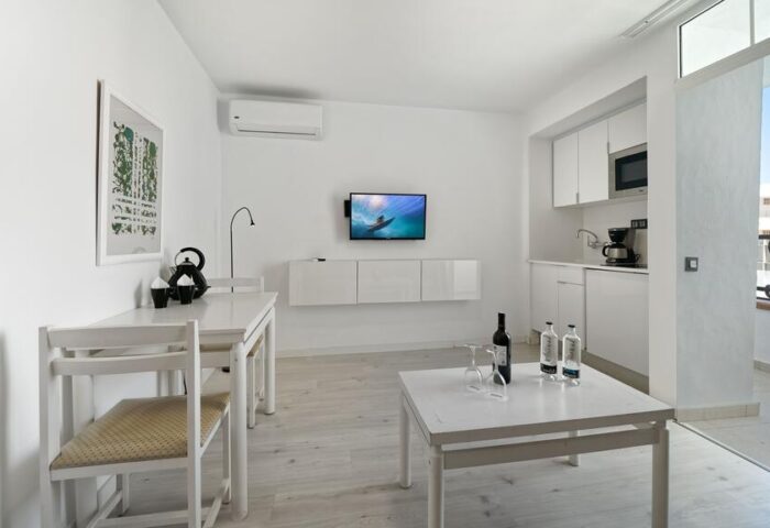 Atlantic Sun Beach gay-friendly hotel room. Interior of a bright apartment with white furniture, kitchenette, and balcony. Gay men only.