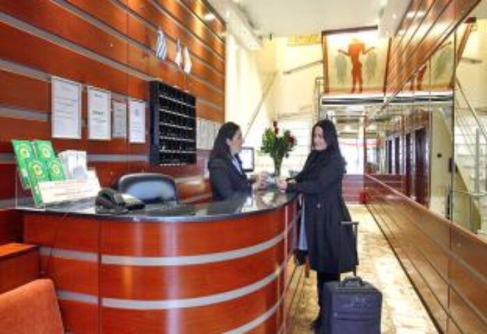 Attalos Hotel's reception area. Gay-friendly hotel in Athens, Greece. A guest checks in at the front desk. Travel advice for gay men.