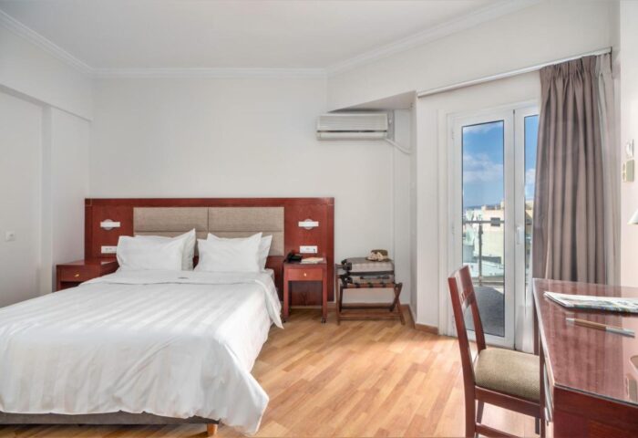 Attalos Hotel room. Gay-friendly hotel bedroom featuring a double bed, desk, & balcony. Ideal for gay men travel in Athens, Greece.