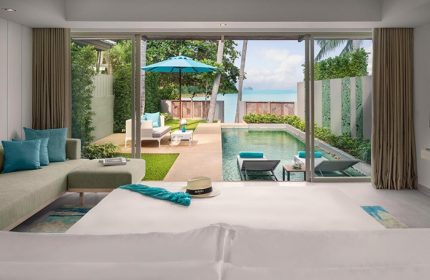 Avani+ Samui Resort gay-friendly hotel room view. Pool, lounge chairs, ocean, and patio furniture visible from the room. Tropical getaway.