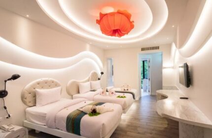 Avatara Resort gay-friendly hotel room. Two beds with decorative towels, flower lamp, and modern design. Gay travel lodging.