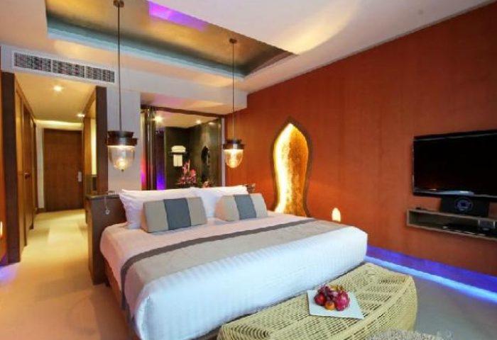 Avista Hideaway Phuket Patong MGallery by Sofitel's gay-friendly hotel room. Luxury bedroom interior with king bed, TV, and fruit basket.