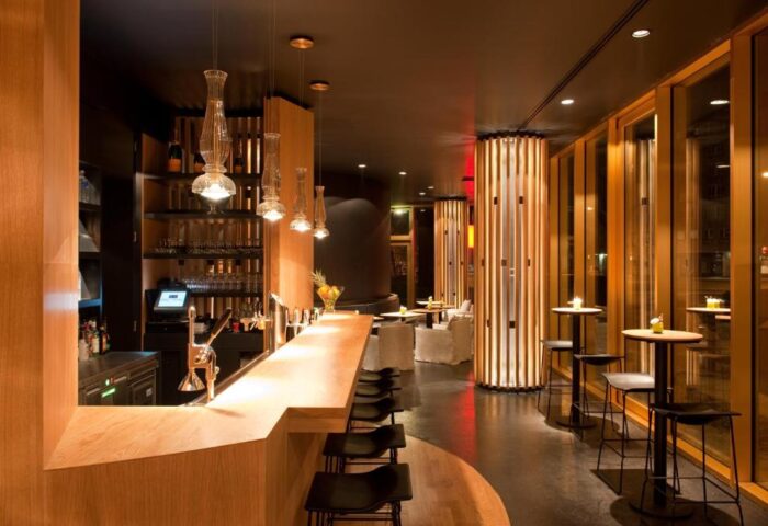 Axel Hotel Berlin-Adults Only gay-friendly hotel bar. Modern design with wood accents, pendant lights, and tables. Gay travel advice.