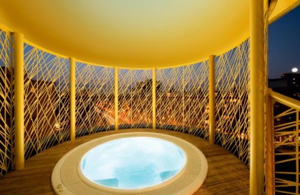 Rooftop jacuzzi at Axel Hotel Berlin-Adults Only, a gay-friendly hotel. Yellow structure, wooden deck, city view. Perfect for gay travel.