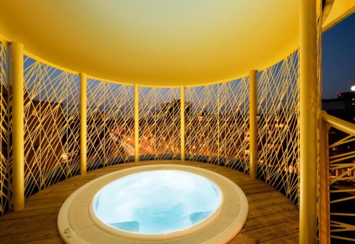 Rooftop jacuzzi at Axel Hotel Berlin-Adults Only, a gay-friendly hotel. Yellow structure, wooden deck, city view. Perfect for gay travel.