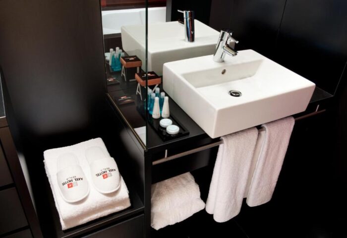 Axel Hotel Berlin Adults Only: Bathroom detail with sink, towels & slippers. Gay-friendly hotel room. Modern design. Perfect for gay travel.