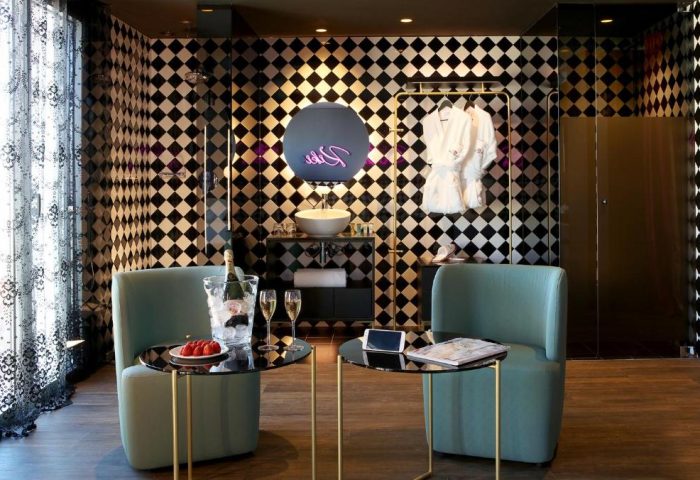 Axel Hotel Madrid adults-only room. Gay-friendly hotel with modern design, black and white diamond pattern, champagne, and luxurious amenities.