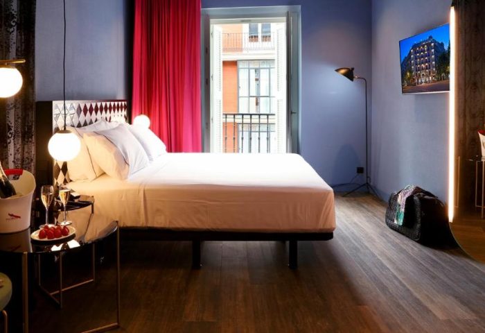 Gay-friendly Axel Hotel Madrid adults-only room. Bed, balcony, champagne, & strawberries. Upscale travel for gay men in Madrid, Spain.