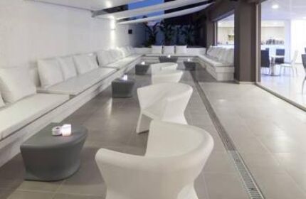 AxelBeach Ibiza Suites lounge area. Gay-friendly, adults-only hotel with modern white seating, tables, and sleek design. Perfect for gay travel.
