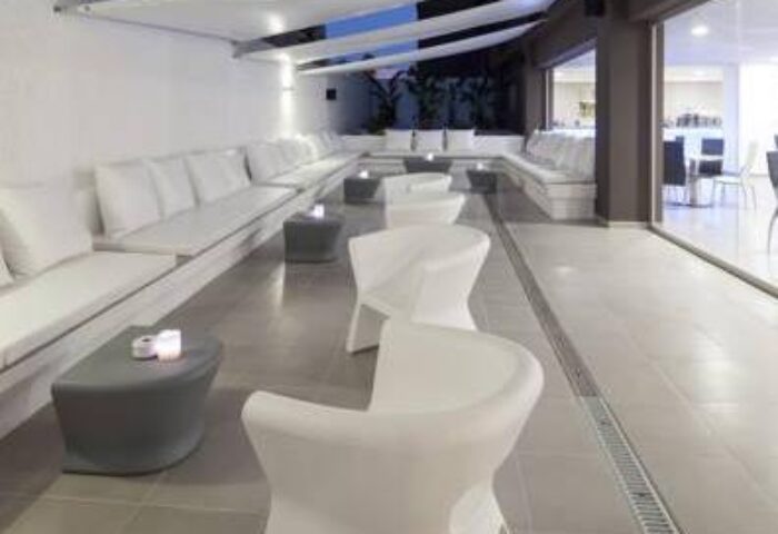 AxelBeach Ibiza Suites lounge area. Gay-friendly, adults-only hotel with modern white seating, tables, and sleek design. Perfect for gay travel.