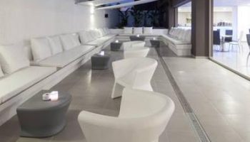 AxelBeach Ibiza Suites lounge area. Gay-friendly, adults-only hotel with modern white seating, tables, and sleek design. Perfect for gay travel.