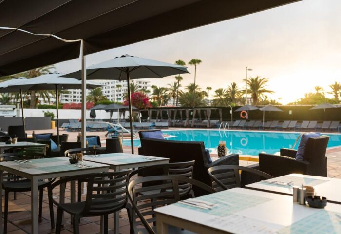 AxelBeach Maspalomas ApartLounge Club-Only Adults outdoor dining area with pool view. Gay-friendly hotel in Gran Canaria, Spain.