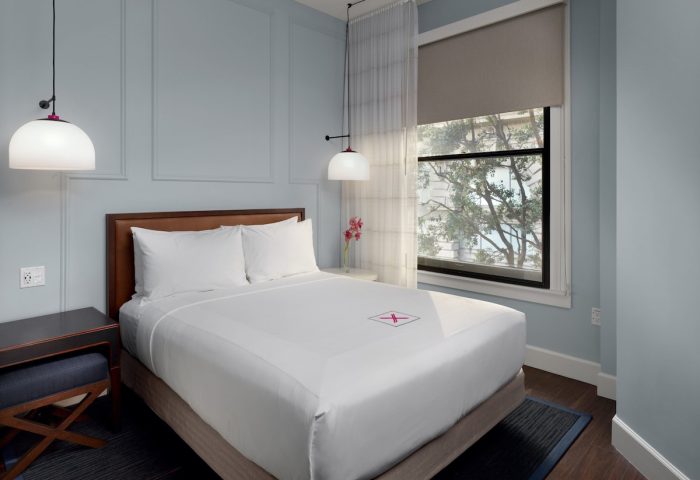 Axiom Hotel room. Gay-friendly hotel room with queen bed, white linens, and modern decor. Window view. Ideal for gay travel.