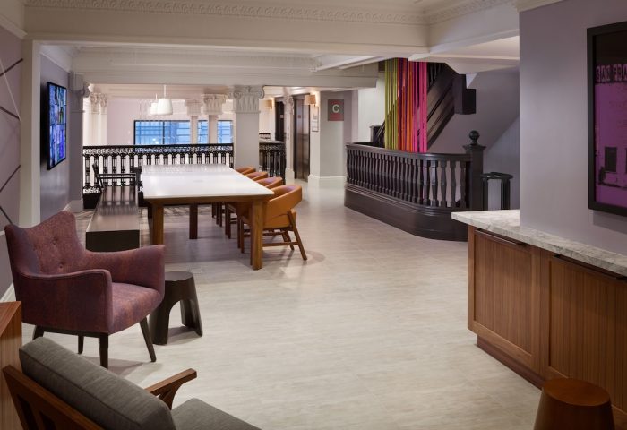 Axiom Hotel's stylish interior. This gay-friendly hotel features a modern lobby with a long table, comfortable chairs, and colorful accents.