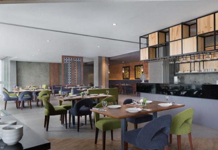 Ayaka Suites gay-friendly hotel restaurant. Tables set with plates and glasses. Modern design with wood accents. Upscale dining for gay travelers.