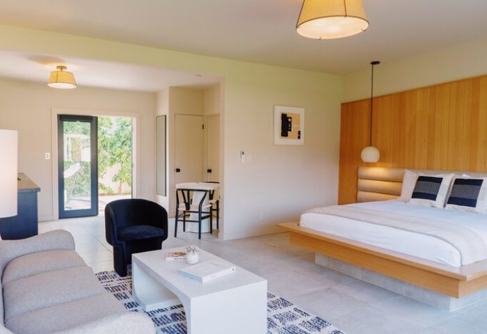 Azure Sky Hotel Adults Only room. Gay-friendly hotel suite with bed, sofa, chair, and outdoor access. Modern design, ideal for gay travel.