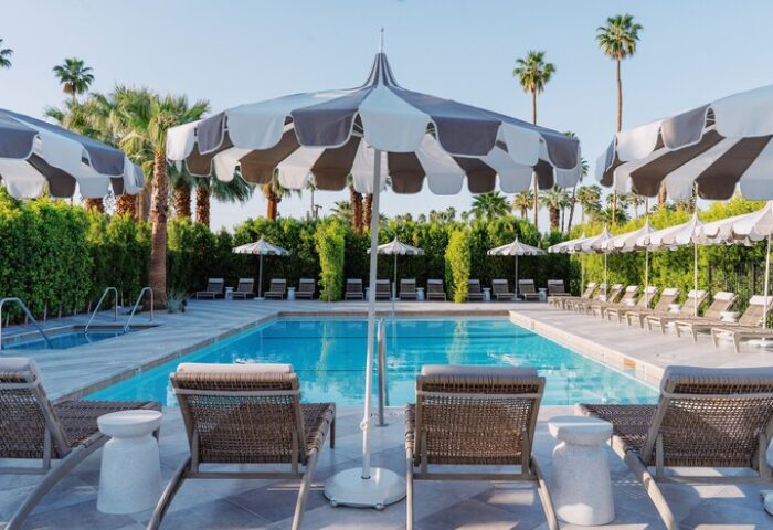 Azure Sky Hotel Adults Only pool area. Gay-friendly hotel with lounge chairs, umbrellas, and palm trees. Relaxing vacation for gay men.