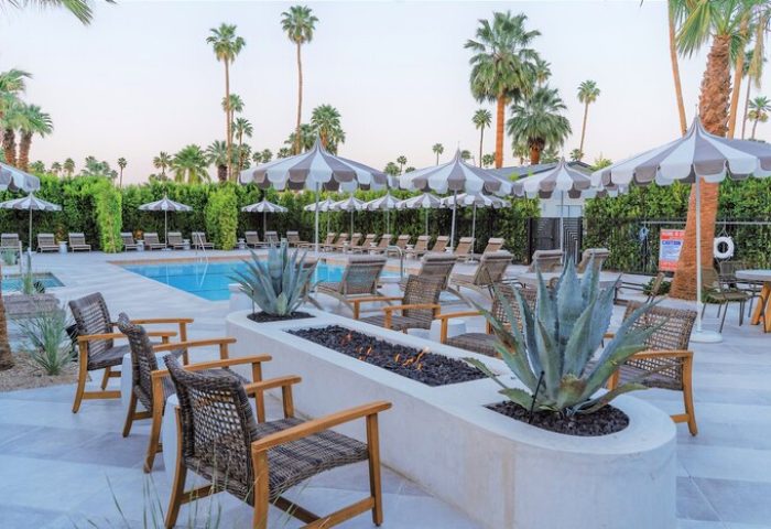 Azure Sky Hotel Adults Only pool area. Gay-friendly hotel with lounge chairs, umbrellas, fire pit, and palm trees. Relaxing, upscale resort.