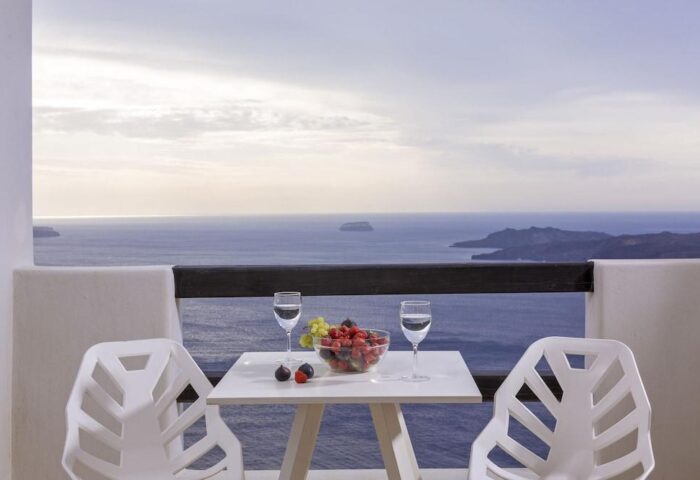 Azzurro Suites, a gay-friendly hotel. Balcony view with fruit, water, and sea. Perfect gay travel destination.