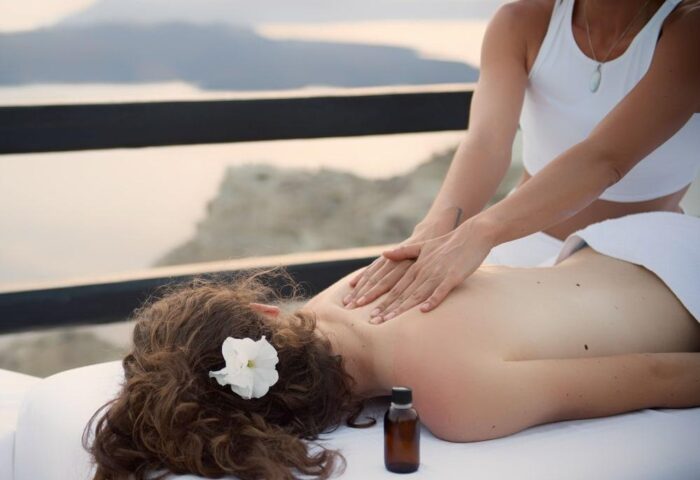 Azzurro Suites gay-friendly hotel: Man receiving a massage overlooking the sea. Relaxing wellness treatment at this gay travel destination.