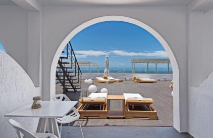 Azzurro Suites gay-friendly hotel rooftop. Lounge chairs, table, and stairs. A perfect spot for gay travelers seeking relaxation. Blue sky view.