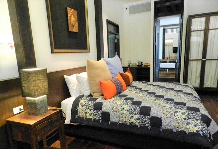 Baan Saen Fang Chiang Mai gay-friendly hotel room. Bed with colorful pillows and quilt. Bathroom view. Ideal for gay men travelers.