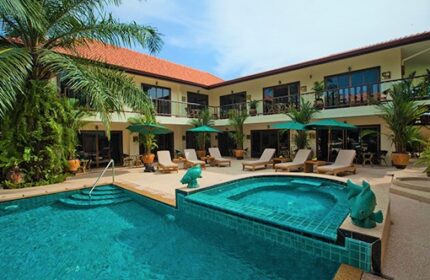 Baan Souy Resort pool area. Gay-friendly hotel with sun loungers, umbrellas, and tropical plants. Ideal for gay men's travel.