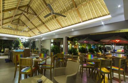 Balinea Villa & Spa gay-friendly hotel restaurant. Thatched roof, ceiling fans, rainbow chairs, tables, and umbrellas. Outdoor dining area.