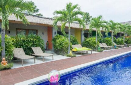 Balinea Villa & Spa pool view. Gay-friendly hotel with colorful rooms, palm trees, and lounge chairs. Perfect for gay travel and relaxation.