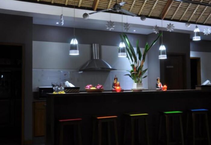 Balinea Villa & Spa kitchen. Gay-friendly hotel bar with stools, plants, and Buddha statues. Modern design, perfect for gay men's travel.