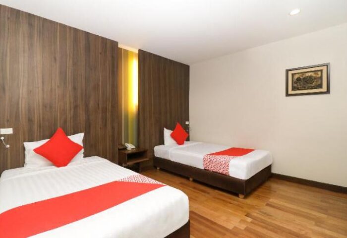 Bally Suite Silom, gay-friendly hotel room with two twin beds, red accents, wood floors. Comfortable lodging for gay travelers in Bangkok.