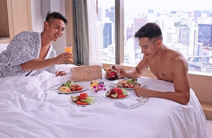 Gay-friendly Banyan Tree Bangkok hotel: Two gay men enjoy breakfast in bed with a city view. Luxury travel experience in Thailand.