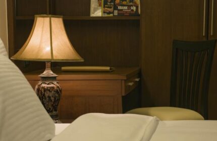 Baywalk Residence detail: Bedside lamp on a desk with magazines, chair. Gay-friendly hotel room interior, comfortable stay. Travel advice.