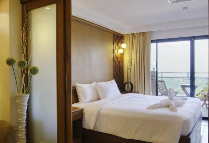Baywalk Residence gay-friendly hotel room. Queen bed with swan towels, balcony view. Modern design, comfortable stay. Perfect for gay travel.