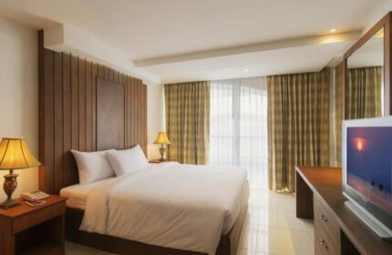 Baywalk Residence gay-friendly hotel room. Queen bed, desk, TV, bedside table with lamp. Comfortable accommodations for gay travelers.