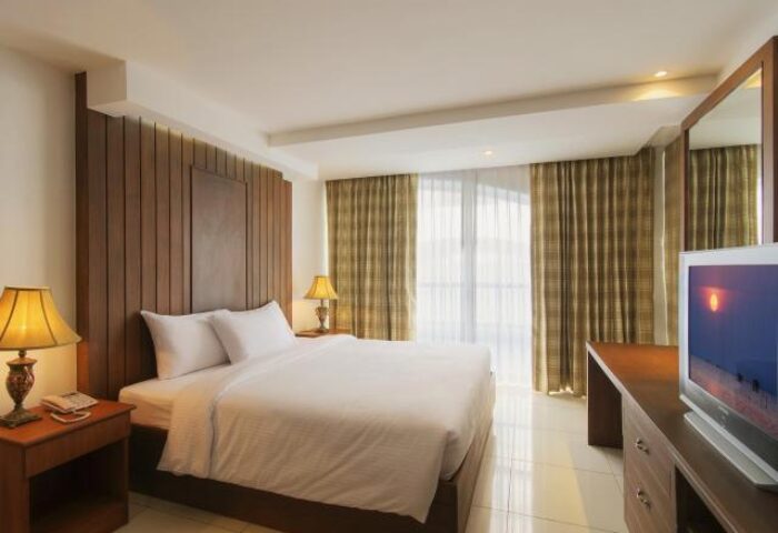 Baywalk Residence gay-friendly hotel room. Queen bed, desk, TV, bedside table with lamp. Comfortable accommodations for gay travelers.